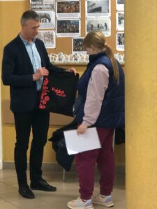 Przedstawiciel Krajowego Ośrodka Wsparcia Rolnictwa wręcza nagrodę uczennicy