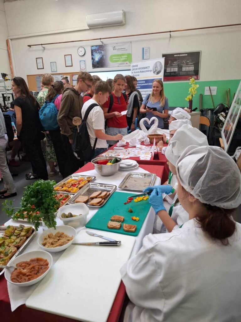 Uczestnicy ,, Miasteczka Zawodów 2024" oglądający stanowisko wystawowe szkoły branżowej